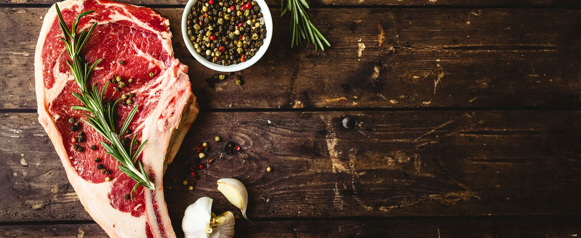 Rohes Fleisch mit Gewürzen auf dunklem Holzboard